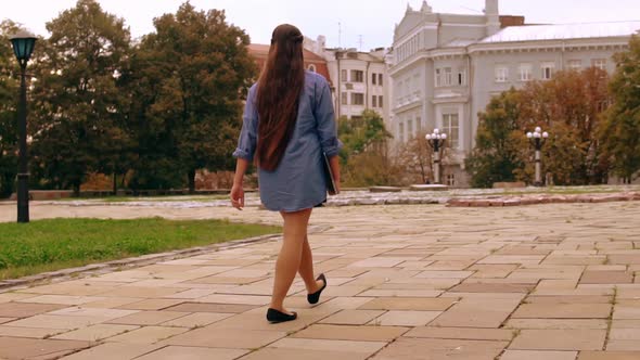 Unrecognizable Student Walks with Computer alt