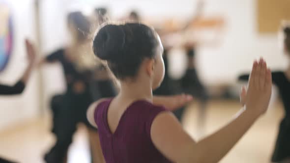 Brunette Caucasian Girl with Brown Eyes Jumping and Spinning in Fourth Position in Dancing School alt
