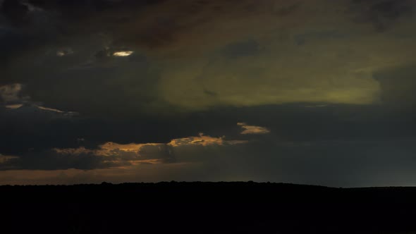 Moon Behind Clouds Above Horizon at Dark Night Timelapse
