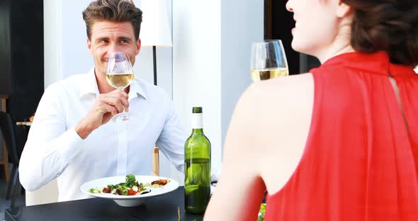 Couple toasting wine glasses while having lunch in a restaurant alt