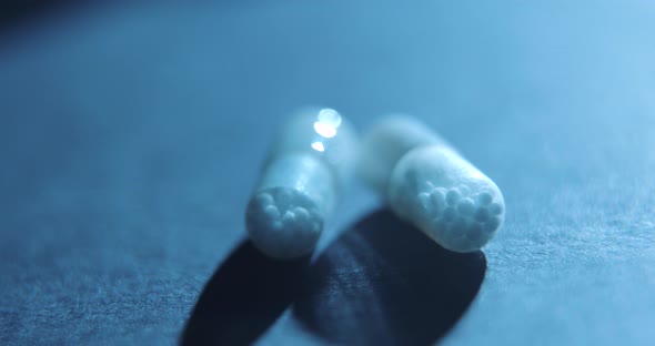 Pills medicine rotating on black background close-up slow motion, studio shot in 4K prores HQ