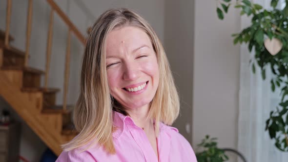 Portrait of Beautiful Blonde Woman with Blue Eyes Looking Up to the Camera and Smiling Charmingly.