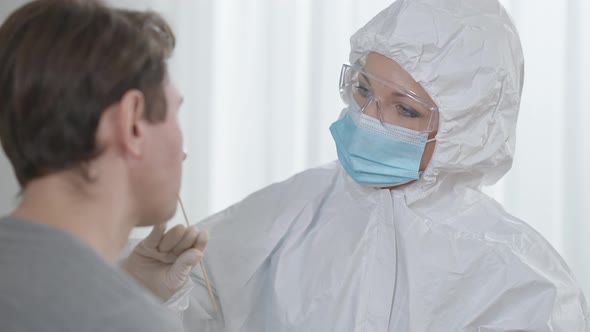 Closeup of Professional Caucasian Female Nurse Taking Covid19 Test Using Cotton Swab alt