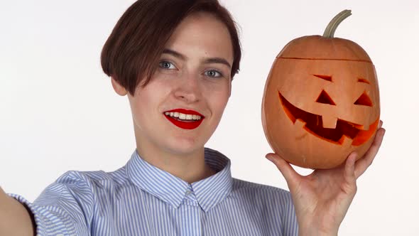 Lovely Red Lipped Woman Taking Selfies with Carved Halloween Pumpkin alt