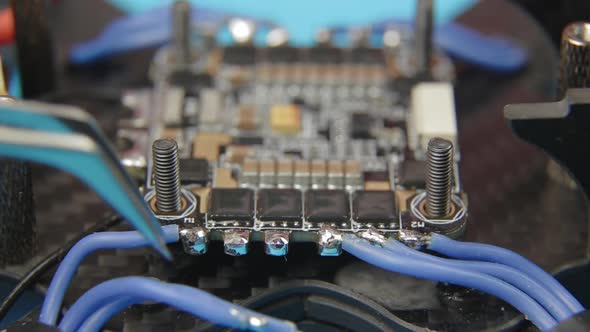 Soldering ESC Contacts. Extreme Close Up of Young Man's Hands Assembling FPV Racing Drone.
