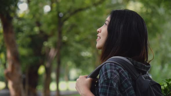 Beautiful young Asian girl looking up at rain in nature.