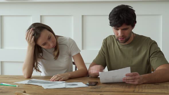 Stressed Young Couple Calculating Monthly Home Expenses Credit Card Bills Payment alt