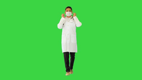 Ethnic Male Doctor Specialist Walk Take Off Protective Medical Mask Put It in Pocket of White Coat