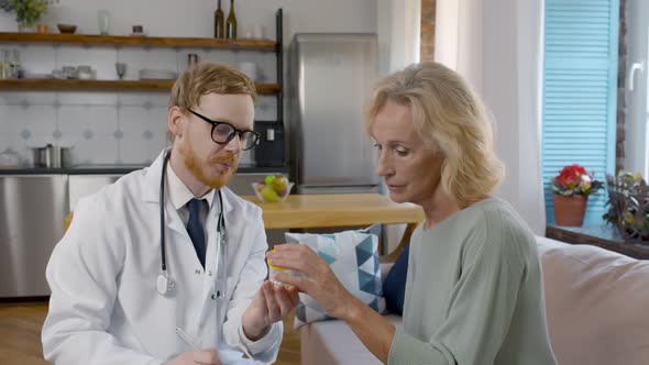 Young Doctor Giving Medial Prescription To Elderly Woman alt