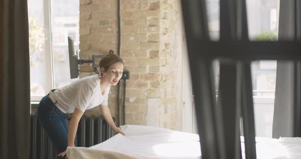 Young Joyful Woman Making Bed in the Morning and Falling Back on White Blanket. Cheerful Carefree alt