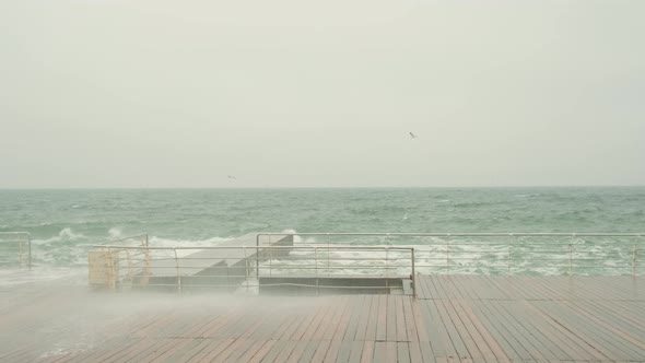 the Sea Promenade is Made of Terraced Boards the Sea is Stormy Waves with Foam Beat on the Pier