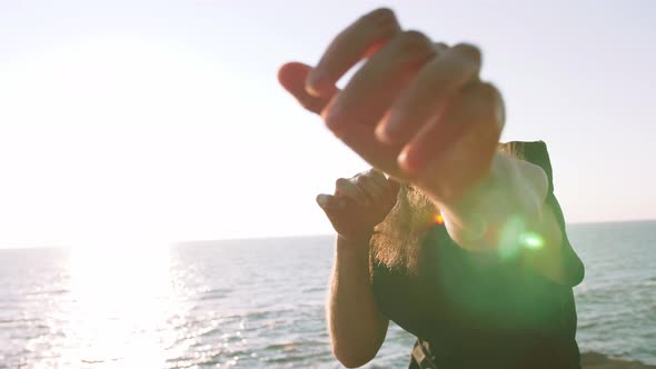 Middle Aged Man with Long Gray Beard Boxing with Shadow in Park During Sunrise alt