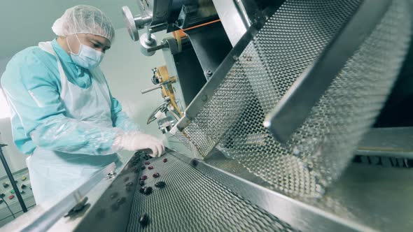 Pharmaceutics, Pharmacy Concept. Male Chemical Worker Is Examining Fresh Pills in a Factory alt