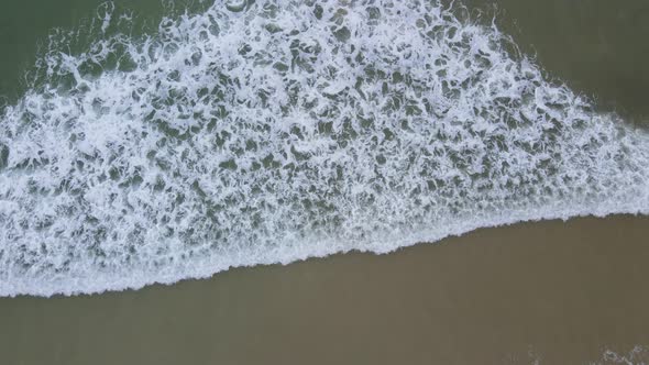 Aerial View of Waves Rolling Into Coastline