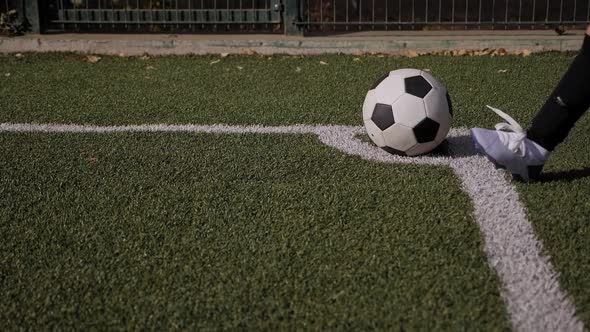 A Little Boy Soccer Player Hits a Corner Kick on a Soccer Field with Green Grass alt