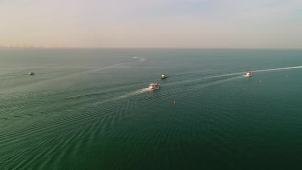 Aerial view of group of yachts sailing in the persian gulf in Dubai, U.A.E. alt