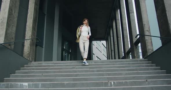 Beautiful Young Woman Goes Down the Stairs Smiling During Wonderful Walking at Positive day alt