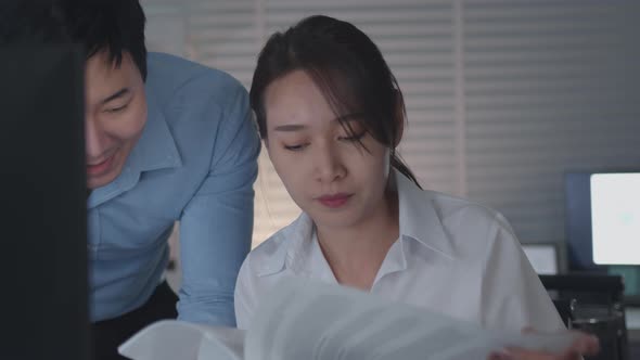 Asian Businessman and Businesswoman looking at desktop computer screen discussing  a business alt