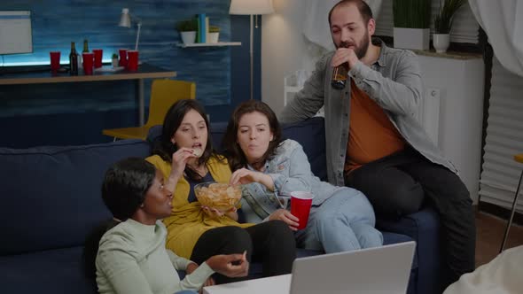 Multiracial Friends Chilling on Sofa in Living Room During Movie Night alt