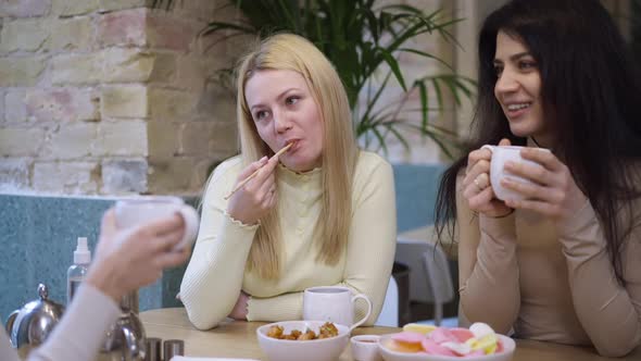 Portrait of Smiling Caucasian Woman Eating Tasty Baked Shrimp with Chopsticks As Middle Eastern Lady alt