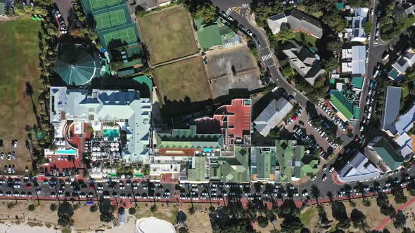 Wide angle top down flying over Camps Bay beach and out over the ocean