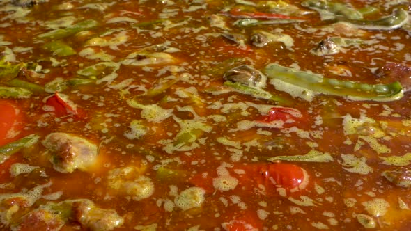 A close up shot of a Spanish Paella being cooked, panning from right to left, slow motion alt