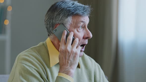 Caucasian Old Greyhaired Man Grandfather at Home Talking on Mobile Phone Remote Conversation Distant alt