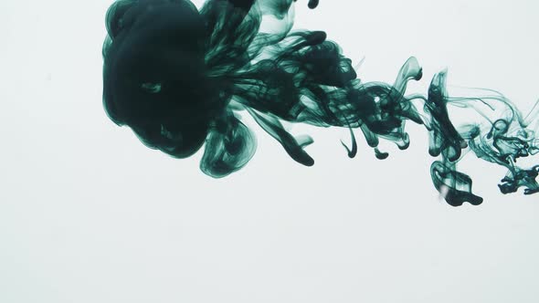 Green Ink Sprayed Into Water On A White Background alt