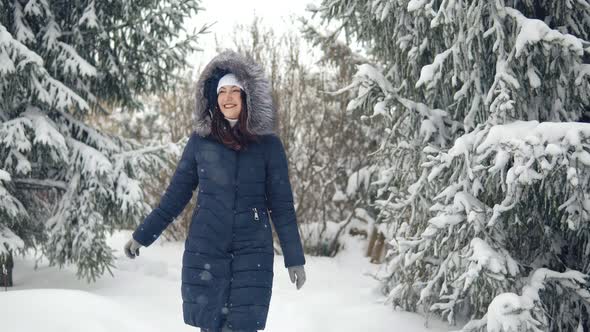 Brunette Woman Walking Along a Trail in a Winter Forest alt