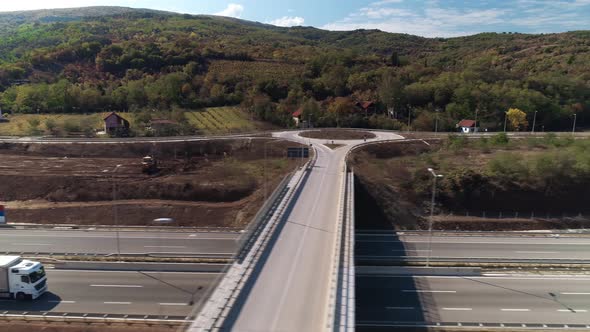Highway, aerial drone shot, big truck passing. Camera moving parallel.