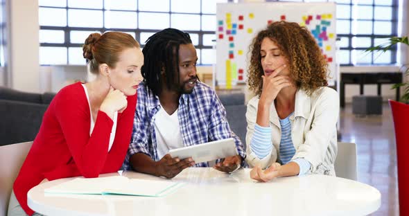 Colleagues interacting with each other over digital tablet alt