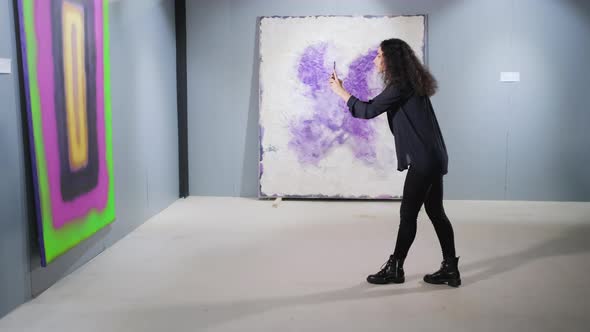 Girl with Mobile Taking Photos in Art Gallery alt