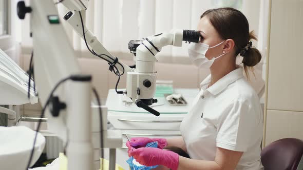 A Female Endodontist Is Treating Canals Under the Microscope. by prostooleh