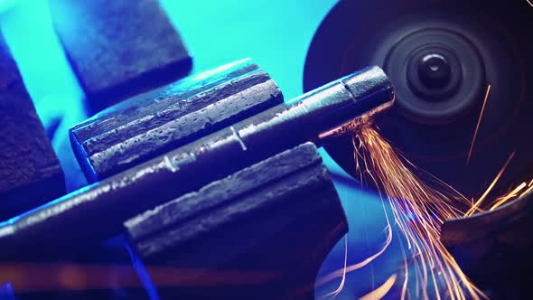 Professional Male Worker Cuts Off Metal Pipe with Grinder Clamping Them in Vise alt