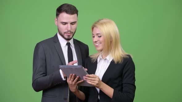 Young Happy Business Couple Using Digital Tablet Together