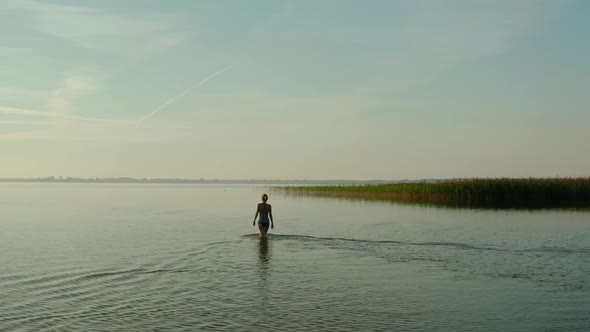Aerial Drone View, Attractive Young Woman Walking in a Lake at Summer Day alt