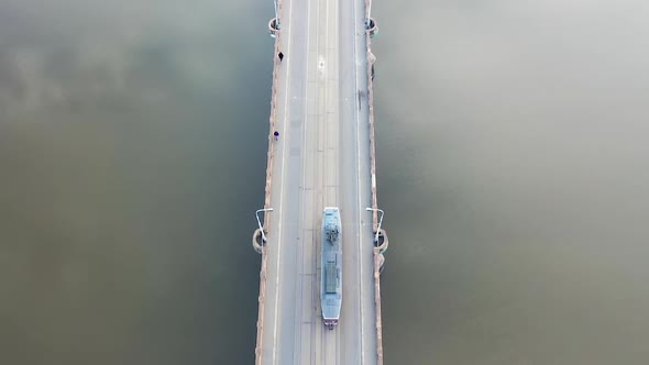 Birdseye Aerial View of Tram Moving on River Bridge With Sky Mirror Reflection. Prague, Czech Republ alt