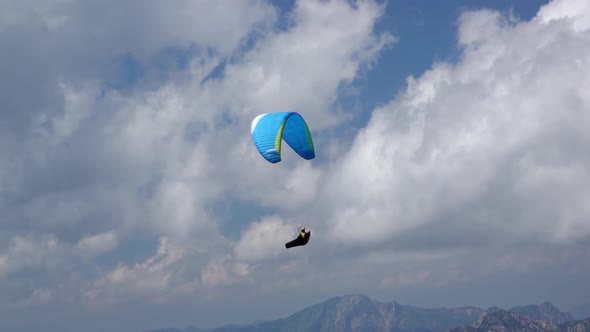Paraglider and Clouds over the Mountains