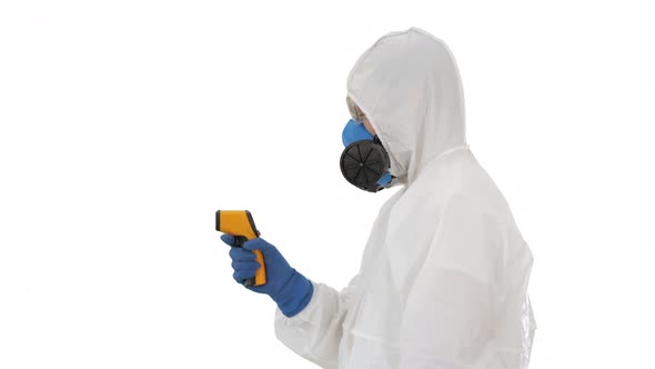 Temperature Check on a Corona Virus Doctor in Protective Suit with Pyrometer on White Background. alt