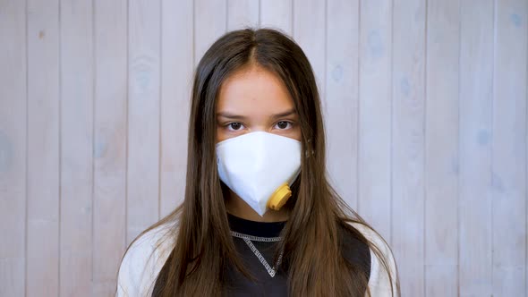 Teenage Girl Wearing Medical Protective Facemask Looking at Camera. Covid-19, Coronavirus Outbreak