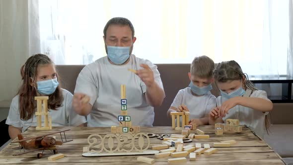 Dad and Kids Play with Wooden Toys and Puzzles in the Room