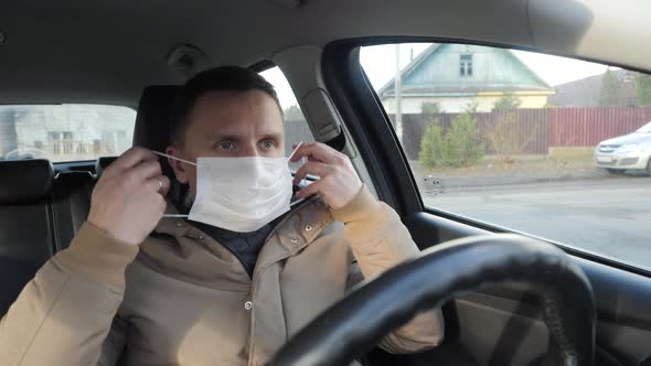 The Driver of the Car Puts on a Medical Mask.