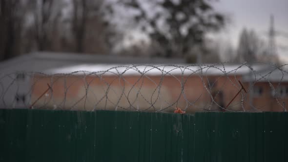 Tall Prison Walls with Barbed Wire the Distant Fence Wires and the Guard Tower is Apparent alt