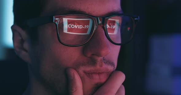 Closeup of Man Working at a Computer Reflected in Glasses Warning of COVID 19 alt