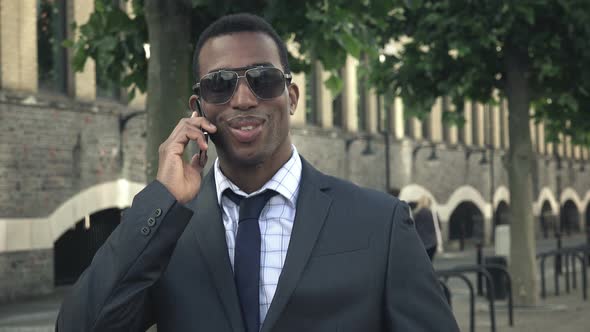 Handsome Young Businessman Working out His Office with A Cell Phone: Smartphone; Mobile Phone alt