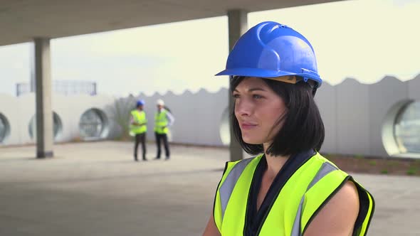 Architect woman confidently looking at camera at construction site