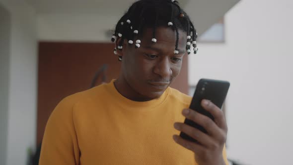 Portrait of Surprised Happy African American Black Man Reading Text Message on His Smartphone alt
