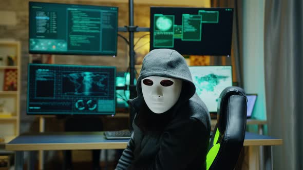 Masked Hacker Wearing a Hoodie To Hide His Identity alt