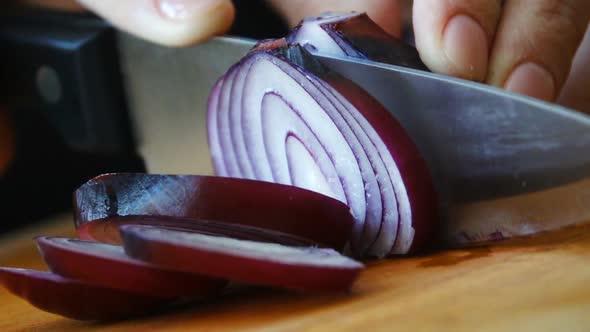 Chopping Onion. Slow Mothion. Red Onions Close Up. Female Hands Cut Onions in Kitchen. Macro