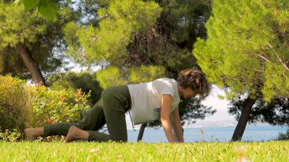 30 Years Old Woman Doing Fitness Exercises on Grass in Park